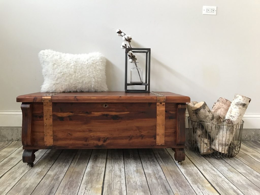 stylish cedar chest used creatively in a living room with a pillow and decor on its lid